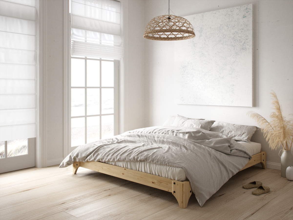 Dwuosobowe, drewniane łóżko bez zagłówka w sypialni zaaranżowanej na poddaszu – w pomieszczeniu ze skosem.