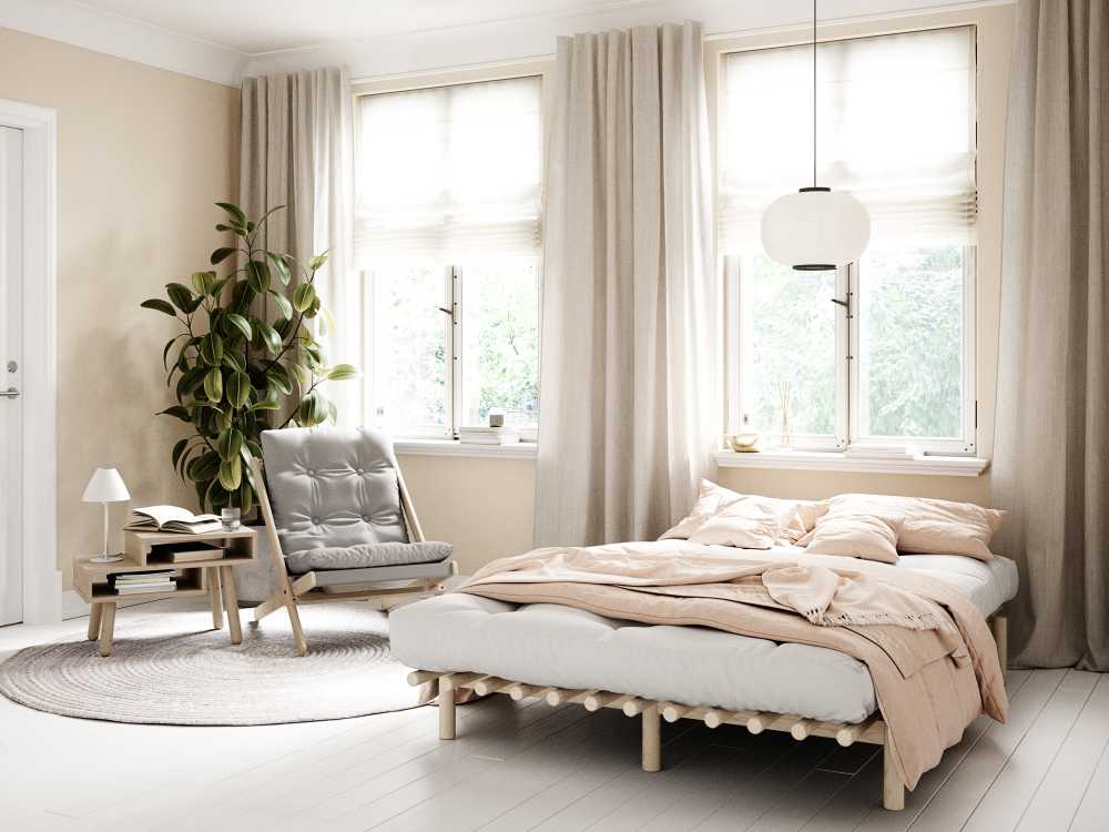 Styl skandynawski i minimalistyczne łóżka z drewna w jasnej i przestronnej sypialni.